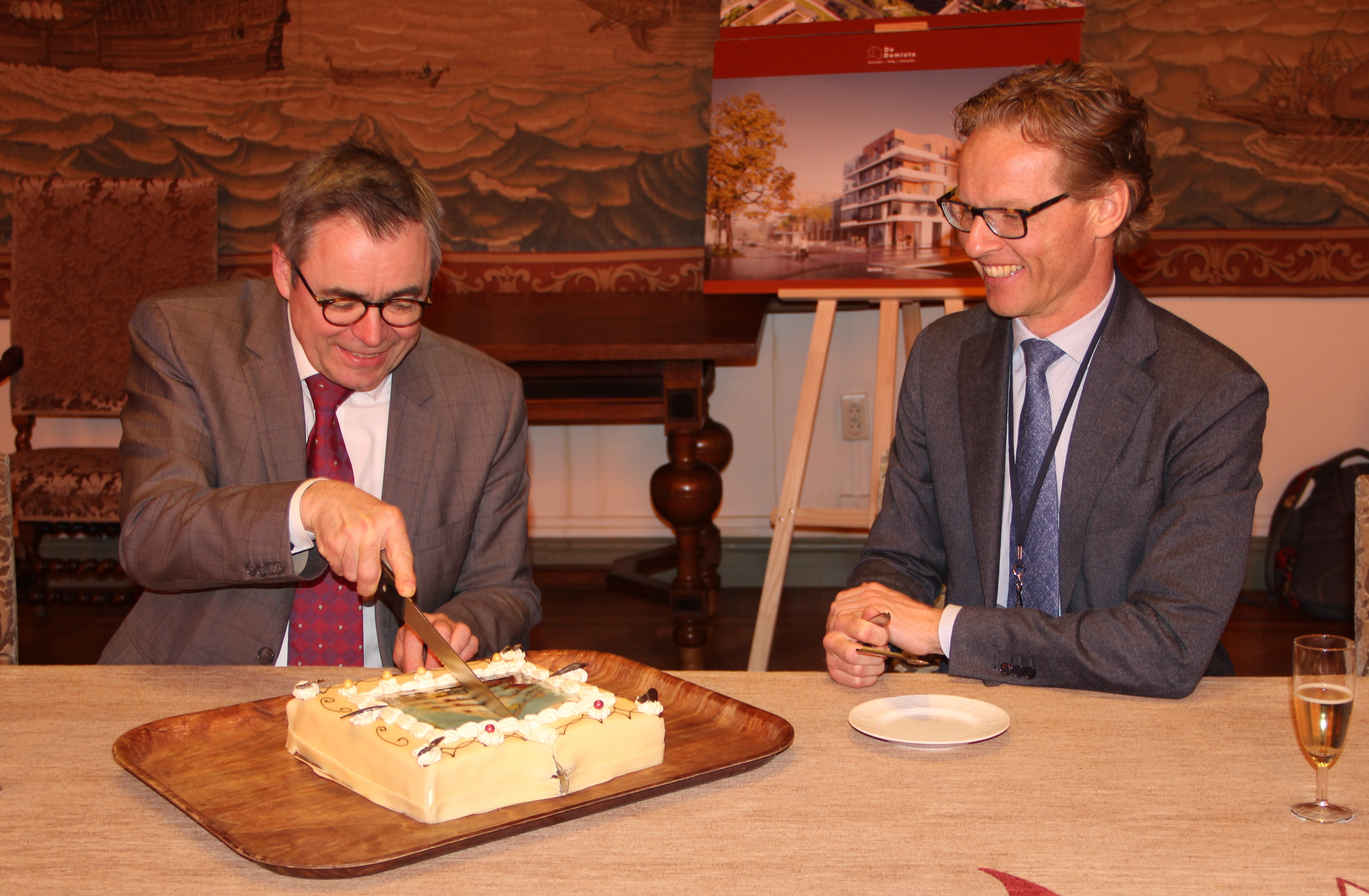 Burgemeester Jos Wienen snijdt de taart aan, Bemog-directeur Stefan van Dijk kijkt toe