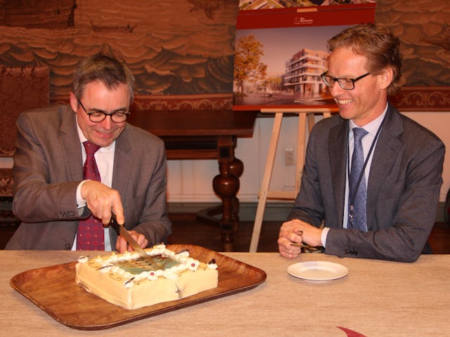 Burgemeester Jos Wienen snijdt de taart aan, Bemog-directeur Stefan van Dijk kijkt toe