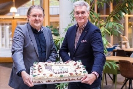 Frans Fonteijn, directeur Zuid bij BAM Wonen (links) en Harrie Oosterlee, directeur-bestuurder WoonGoed 2-Duizend (rechts) onthullen de samenwerking met een feestelijke taart.